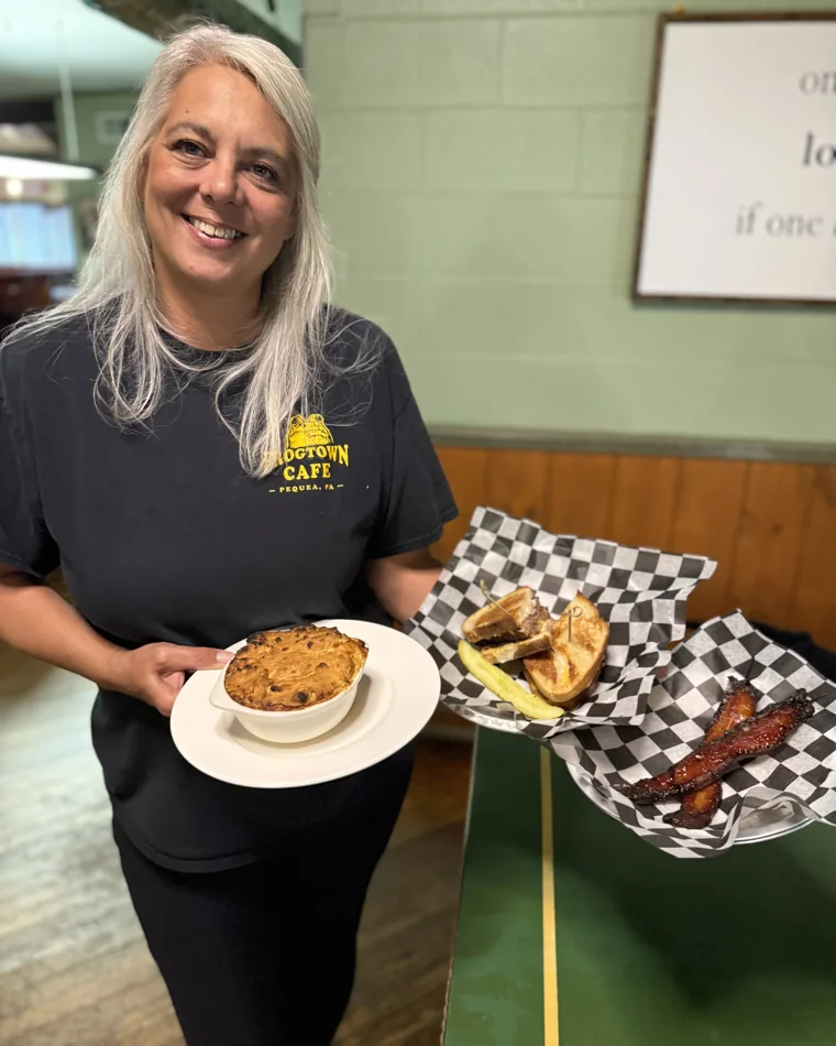Janie, the owner, holding Frogtown fall specials: the cornbread-crusted chicken pie, a grilled meatloaf sandwich, and maple-bourbon bacon skewers